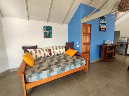 um quarto com um sofá e uma parede azul em TAHITI - Taharaa Beach Bungalow em Arue