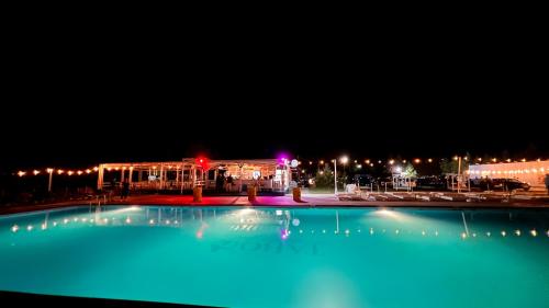 ein großer Swimmingpool in der Nacht mit einem Gebäude in der Unterkunft Mojo Beach in Budeasa Mare