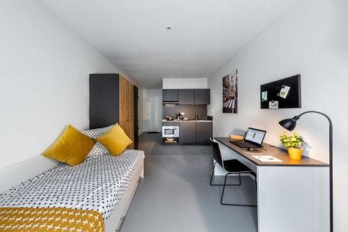 a bedroom with a bed and a desk with a laptop at Green Stay in Essen