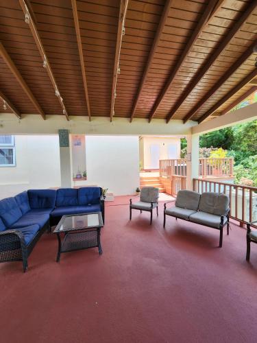a large living room with a blue couch and tables at flamboyantvilla in Gros Islet