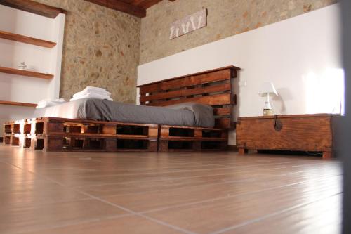 una camera con un letto in legno di recupero di Ospitalita Diffusa Jungi Mundu - Casa Diritti Umani a Camini