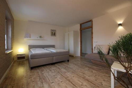 1 dormitorio con 1 cama y 1 sofá en una habitación en Ferienwohnung in herrlicher Teichlandschaft, 