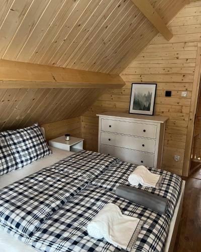 a bedroom with a bed and a wooden ceiling at Aparthouse Siemiany in Siemiany