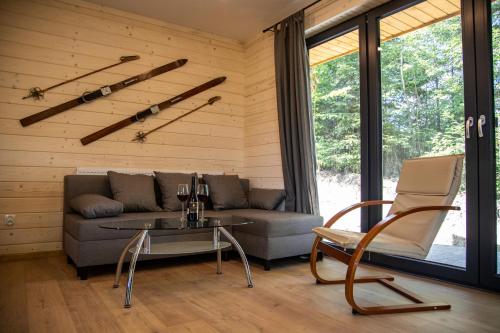 ein Wohnzimmer mit einem Sofa, einem Tisch und Stühlen in der Unterkunft Domki Krynica in Krynica-Zdrój