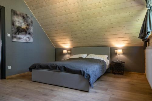 a bedroom with a bed with a wooden ceiling at Domki Krynica in Krynica Zdrój