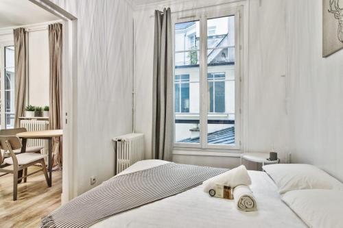 une chambre blanche avec un lit et une fenêtre dans l'établissement Beautiful flat just nearby Madeleine in Paris - Welkeys, à Paris