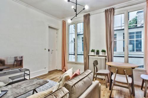 un salon avec un canapé et une table dans l'établissement Beautiful flat just nearby Madeleine in Paris - Welkeys, à Paris