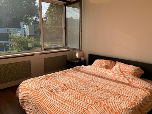 um quarto com uma cama e duas janelas em Cozy Dutchie House Near Utrecht em Nieuwegein