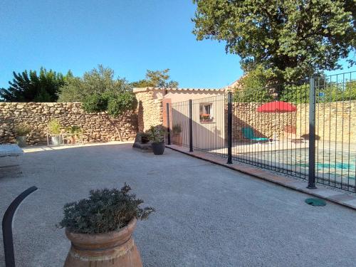a fence with a gate in front of a building at Gite d'Emma in Camaret-sur-Aigues