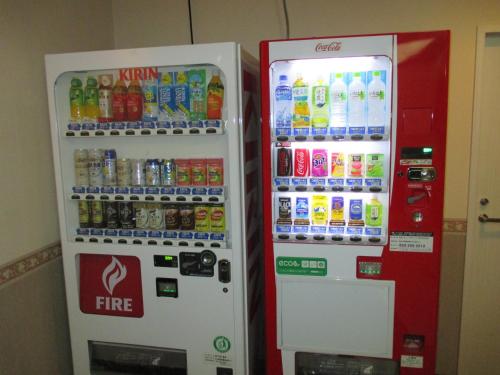 two soda machines are sitting next to each other at Hotel Green With in Sendai