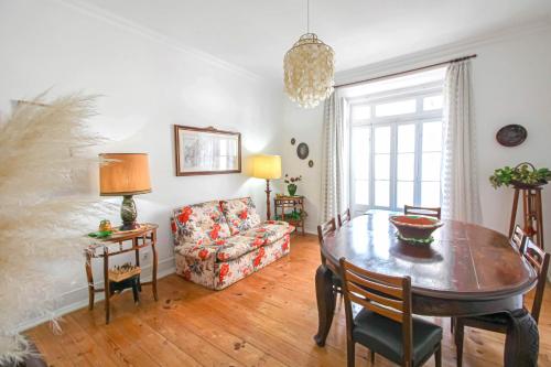 uma sala de estar com uma mesa e um sofá em Donapart em Lisboa