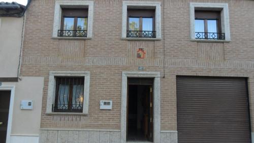 un edificio de ladrillo con puerta y ventanas en Casa Rural El Arrabal, en Piña de Campos