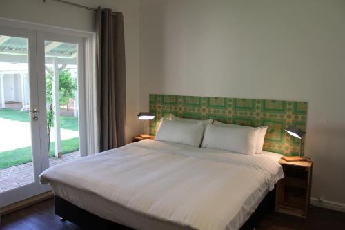 マーガレットリバーにあるGilgara Retreatのベッドルーム1室(ベッド1台、大きな窓付)