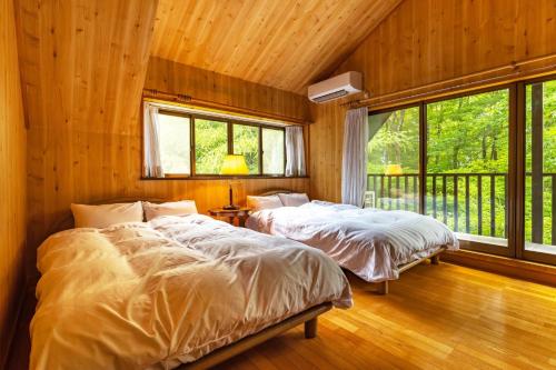 2 Betten in einem Schlafzimmer mit Holzwänden und Fenstern in der Unterkunft Ve-Nasu - Vacation STAY 13252 in Nasu