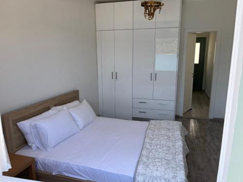 um quarto com uma cama e um armário branco em Modern cottage on the sea em Vathi