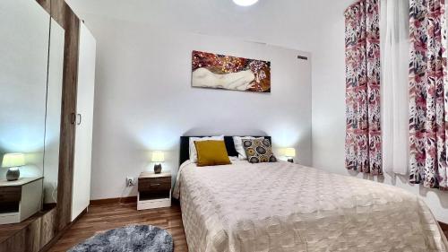 um quarto branco com uma cama e 2 candeeiros em Ground Floor Apartment em Praga