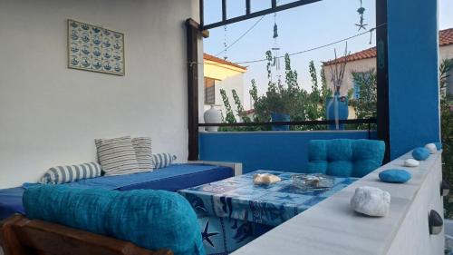 um pátio com uma mesa e um sofá azul em Island house in Elika - Marathias em Elíka