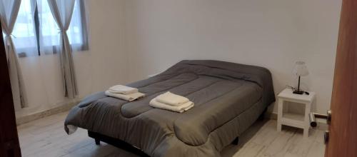 una camera da letto con un letto e due asciugamani di Dúplex 1 Luján de Cuyo a Ciudad Lujan de Cuyo