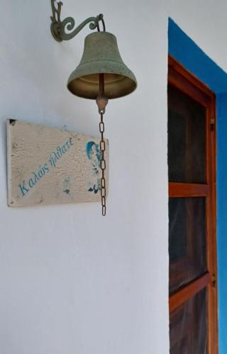 a bell hanging from a wall next to a door at Island house in Elika - Marathias in Elíka