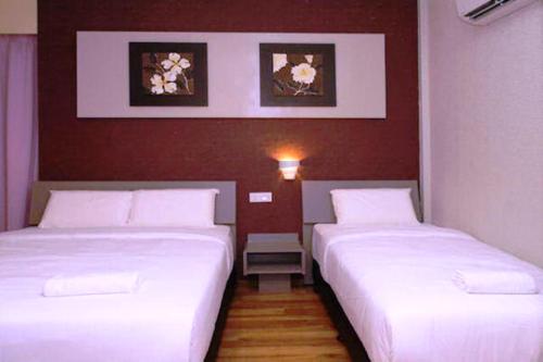 
a hotel room with two beds and two lamps at Ipoh Boutique Hotel in Ipoh
