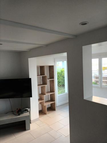 un salon avec une télévision à écran plat sur un mur dans l'établissement Ty Mor, à Plougonvelin