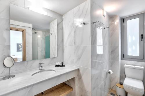 a white bathroom with a sink and a mirror at Acropolis City Life BH in Athens