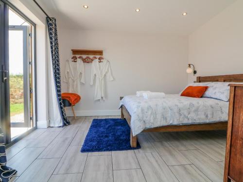 1 dormitorio con cama y alfombra azul en The Cadeleigh, en Tiverton