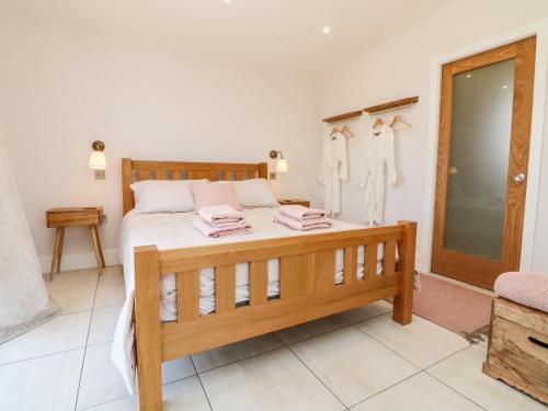 a bedroom with a bed with white sheets and pink towels at The Bickleigh in Tiverton