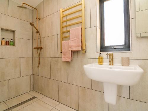 baño con lavabo blanco y ventana en The Bickleigh, en Tiverton