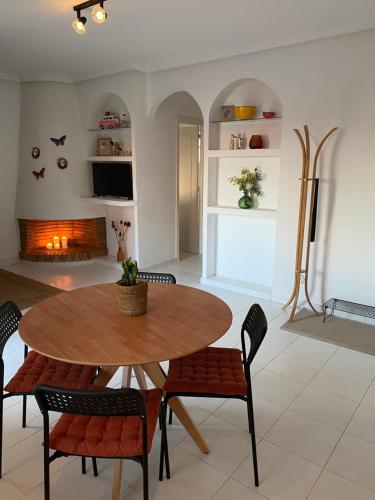 jadalnia ze stołem i krzesłami oraz kominkiem w obiekcie Casa La Mata w mieście Torrevieja