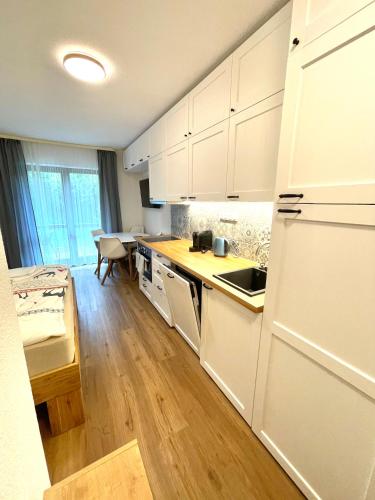 a kitchen with white cabinets and a counter top at 2022 Neu renoviert- Apartments Michaela in Philippsreut
