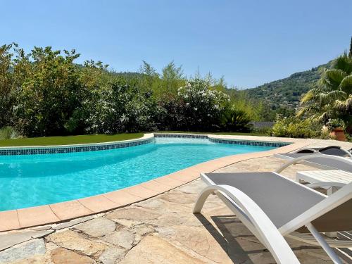 a swimming pool with a chair and a table and a chair at Mas Giro in Le Bar-sur-Loup