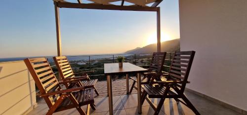 a table and chairs on a balcony with a view at Casa di Olive, all seasons accommodation in Goúdhouros