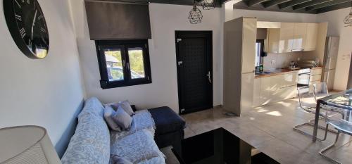a living room with a blue couch and a kitchen at Casa di Olive, all seasons accommodation in Goúdhouros
