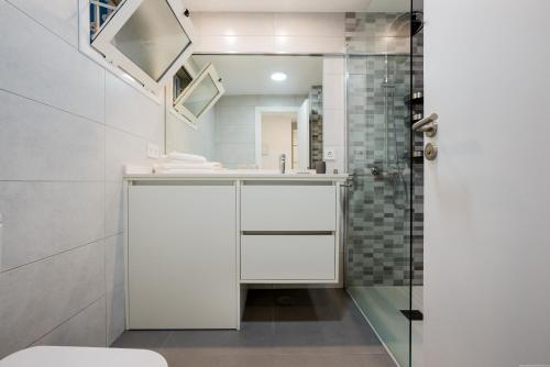 Apartamento Blanco 127 en La Caleta - Altamira في أديخي: حمام مع حوض ودش
