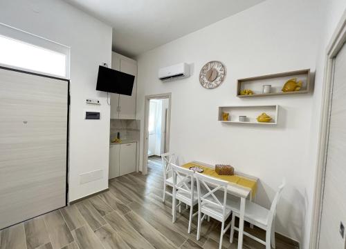 eine Küche und ein Esszimmer mit einem Tisch und Stühlen in der Unterkunft Sunshine in Santa Maria di Castellabate