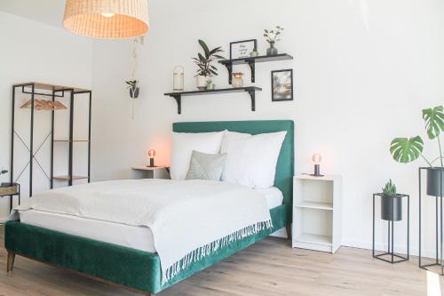 Schlafzimmer mit einem Bett mit einem grünen Kopfteil in der Unterkunft Tropical Apartment in Koblenz
