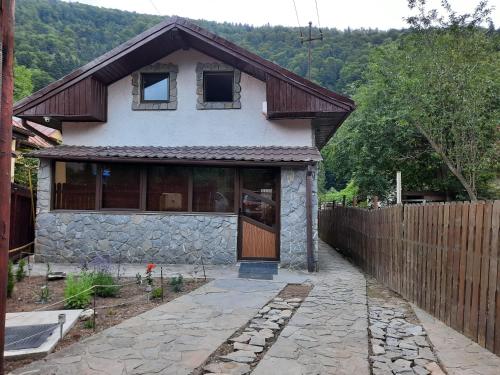 ein Haus mit einer Holztür und einem Zaun in der Unterkunft Casa Crissio in Sinaia