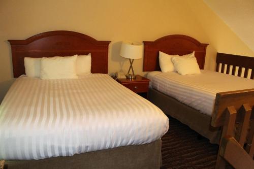 a hotel room with two beds and a lamp at Ramada by Wyndham Campbell River in Campbell River