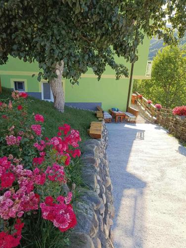 a garden with pink flowers next to a building at Apartmani Vila na Drini in Foča