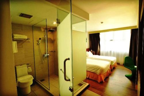 a bathroom with a bed and a shower and a toilet at French Hotel in Ipoh