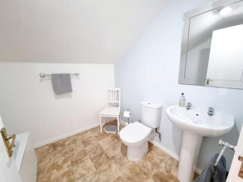 Baño blanco con aseo y lavamanos en One Bed Holiday Home in the Heart of Inverness en Inverness