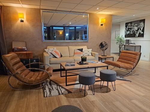 a living room with a couch and chairs and a table at Hôtel Le Collier in Antibes