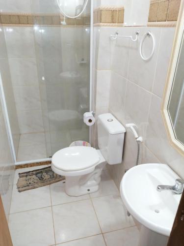 a bathroom with a toilet and a shower and a sink at CASA AMARELA in Salvador