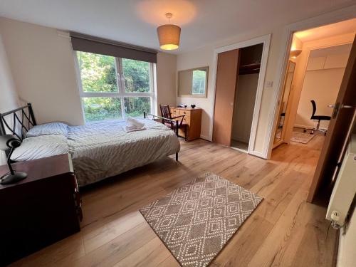 a bedroom with a bed and a rug on a wooden floor at Lovely 2-Bed Serviced apartment with free parking in Glasgow