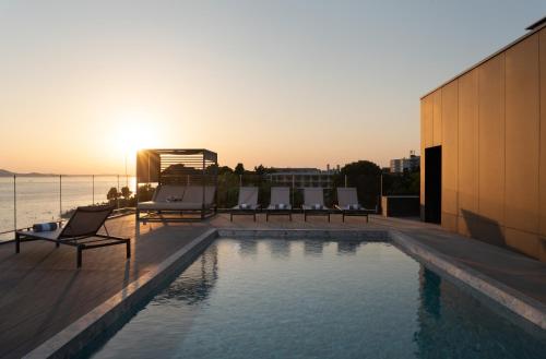 a swimming pool on the roof of a building with the sunset at La Vista Suites in Zadar
