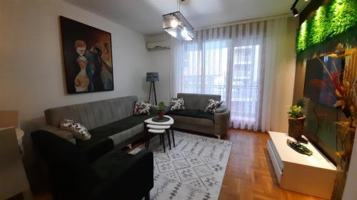 een woonkamer met een bank en een tafel bij Jeta Apartment in Pristina