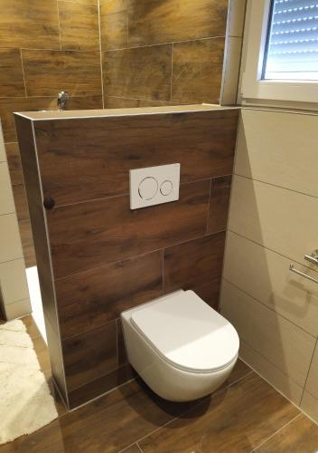 a bathroom with a white toilet in a room at Ferienhof-Dachsberg Wohnung Highlander in Bermatingen
