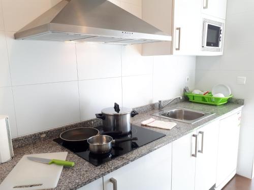 a kitchen with a stove and a sink at Apartamentos Somo1 in Somo