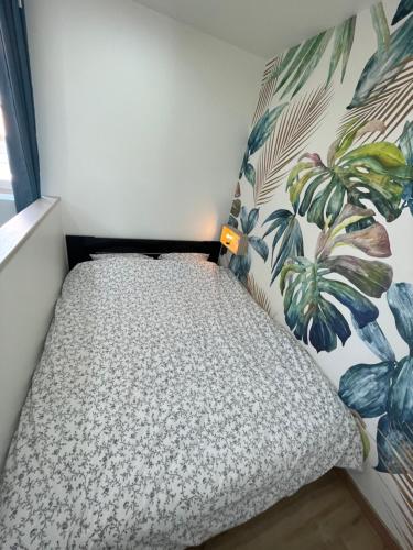 a small bed in a room with a plant wall at La Maison 19 : Studio 2 personnes Louvre Lens in Lens